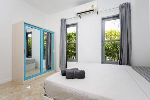 Sisters Ari 2-bedrooms house, Bang Tao beach في Ban Thalat Choeng Thale: غرفة نوم بها سرير ومرآة كبيرة