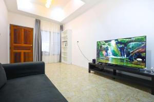 Sisters Ari 2-bedrooms house, Bang Tao beach في Ban Thalat Choeng Thale: غرفة معيشة مع تلفزيون بشاشة مسطحة كبيرة
