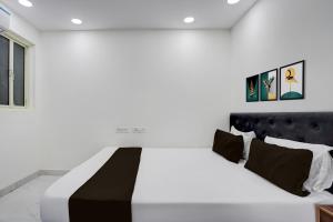 a white bedroom with a black and white bed at Hotel Cashev & front of Paharganj Side Railway station in Jāmb