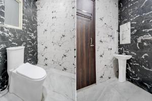 a black and white bathroom with a toilet and a sink at Hotel Cashev & front of Paharganj Side Railway station in Jāmb +20 photos