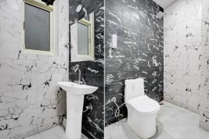 a black and white bathroom with a toilet and a sink at Hotel Cashev & front of Paharganj Side Railway station in Jāmb