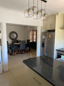 Cape TownUbuntu Guest House的厨房以及带台面和桌子的客厅。