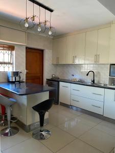 Cape TownUbuntu Guest House的一个带黑色柜台和水槽的大厨房