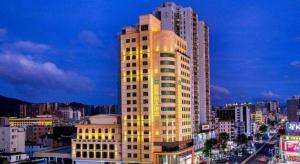 ein hohes Gebäude mit Licht in einer Stadt in der Unterkunft New Regent Hotel in Huizhou