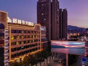 a city skyline with tall buildings and a large billboard at GreenTree Eastern Dali Railway Station Hotel in Dali