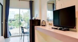 a living room with a flat screen television on a counter at OYO 902 Life and Love Resort in Ban Khlong Haeng