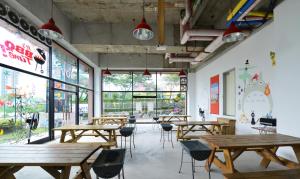 a cafeteria with wooden tables and chairs and large windows at Nova Motel in Boryeong