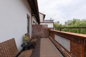 a balcony with two chairs and a table at Floral Hotel Gaosheng in Zhangzhou