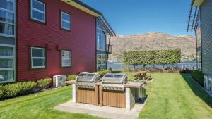 a barbecue grill in a yard next to a building at Marina Apartment 406 in Queenstown