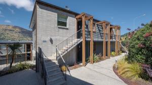 a house with a staircase in front of it at Marina Apartment 406 in Queenstown +16 photos