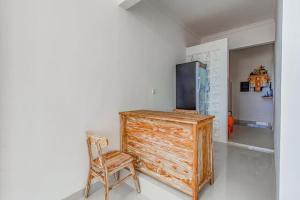 Zimmer mit einem Holzschrank und einem Stuhl in der Unterkunft The Lavana Hi Inn GWK in Uluwatu