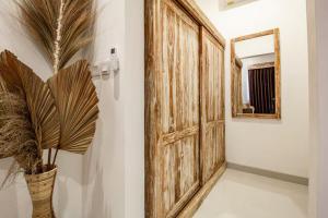 Zimmer mit Holztür und Pflanze in der Unterkunft The Lavana Hi Inn GWK in Uluwatu