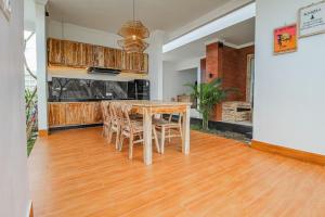 ein Esszimmer mit einem Holztisch und Stühlen in der Unterkunft The Lavana Hi Inn GWK in Uluwatu