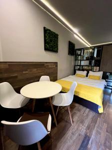 a bedroom with a bed and a table and chairs at Varna Cathedral Apartments in Varna City