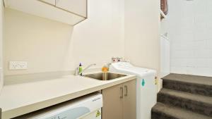 a small kitchen with a sink and a staircase at Couple’s Retreat in Queenstown