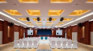a conference room with white chairs and a stage at Yiwu Yimei Plaza Hotel in Yiwu