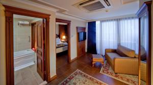 ein Wohnzimmer mit einem Sofa und einem Badezimmer in der Unterkunft GLK PREMIER The Home Suites & Spa in Istanbul