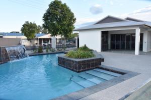 a garden area with a pool and a bench at Western Downs Motor Inn in Miles