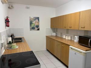 a kitchen with wooden cabinets and a black stove top oven at Ty Cwmbwrla in Swansea