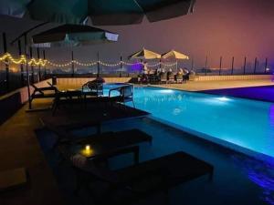 une piscine la nuit avec tables et parasols dans l'établissement Hotel Tower Inn, Chittagong, à Chittagong Port