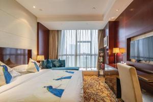 ein Hotelzimmer mit einem großen Bett und einem Flachbildfernseher in der Unterkunft Hangzhou Huachen Fengting Hotel in Hangzhou + 265 Fotos