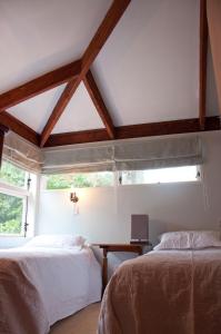 1 dormitorio con 2 camas y ventana en The Cottage, en Wairoa