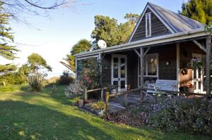 ein kleines Haus mit einer Veranda und einem Hof in der Unterkunft The Cottage in Wairoa