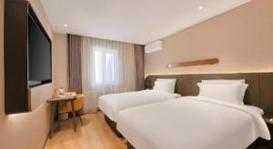 a hotel room with two beds and a flat screen tv at Jinjiang Inn Changchun Pepole Square in Changchun +203 photos