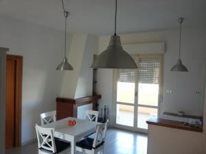 アルゲーロにあるCasa del Lidoのキッチン(白いテーブル、椅子、ペンダントライト付)