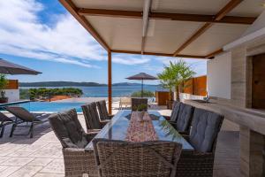 una zona pranzo all'aperto con tavolo e sedie di Villa Paladium a Trogir