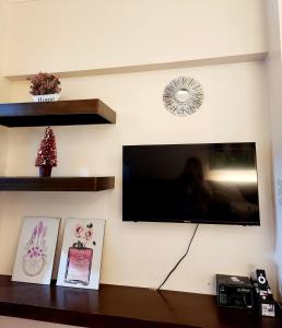 ein Flachbildfernseher, der an einer Wand hängt in der Unterkunft Tagaytay Condo Staycation- Taal-view with balcony in Iruhin + 3 Fotos