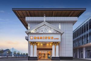 a building with a sign on the front of it at Yichang Vienna Hotel Wanda Branch in Yichang