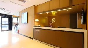 a man sitting at a reception desk in a lobby at IU Hotel Tianjin Tianta Scenic Spot Wujiayao Metro Station in Tianjin
