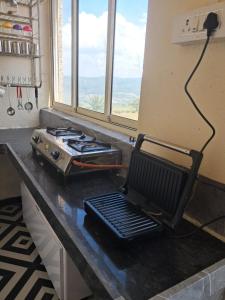 a kitchen counter with a stove and a chair on it at 4, Seascape in Dapoli