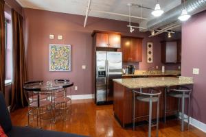 a kitchen with purple walls and bar stools at The Giacomo, an Ascend Collection Hotel in Niagara Falls