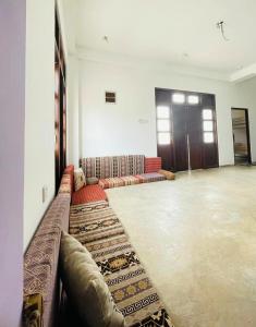 a large room with couches and rugs on the floor at Kuchu surf hostel in Weligama