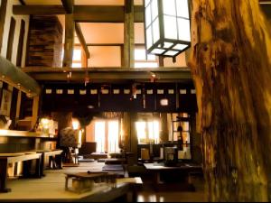 ein großer Raum mit Tischen und Stühlen und Fenstern in der Unterkunft Auberge Kitano Dandan in Abashiri