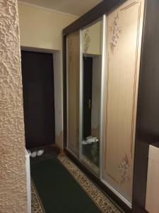 une pièce avec une porte vitrée et une porte avec un miroir dans l'établissement Квартира, à Kozevo