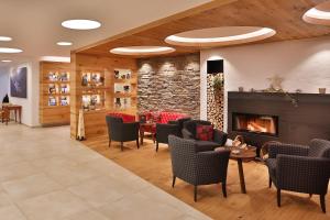 a lobby with a fireplace and chairs and a table at Hotel Zum Mohren in Reutte