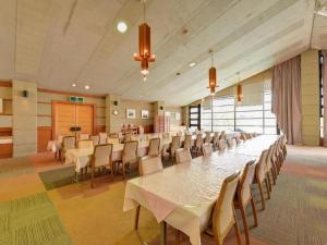 a large banquet hall with a long table and chairs at Oze Iwakura Resort Hotel in Tokura