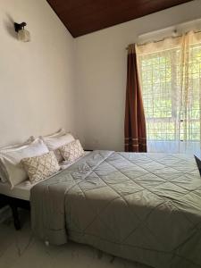 ein Schlafzimmer mit einem Bett und einem Fenster in der Unterkunft The Coffee Retreat in Mudigere