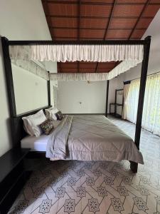 ein Bett mit Baldachin in einem Schlafzimmer in der Unterkunft The Coffee Retreat in Mudigere