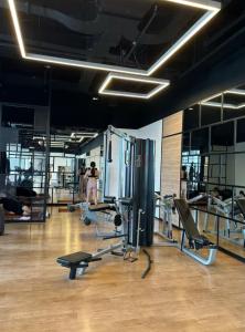 a gym with cardio equipment and people in the background at Newton 1 CBD Jakarta Sudirman in Jakarta