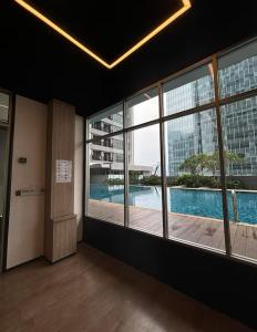 a room with large windows and a swimming pool at Newton 1 CBD Jakarta Sudirman in Jakarta