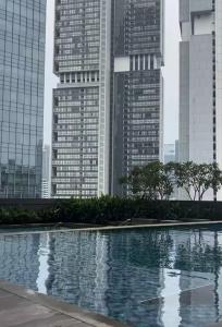 a pool in the middle of a city with tall buildings at Newton 1 CBD Jakarta Sudirman in Jakarta +8 photos