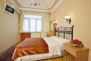 a bedroom with a bed and a table with flowers on it at Side Hotel in Istanbul