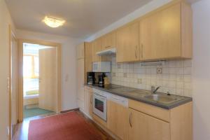 a kitchen with wooden cabinets and a sink at Appartement Ebster in Pettneu am Arlberg