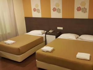 two beds sitting next to each other in a room at Cukai View Hotel in Kampong Nipah Panjang +98 photos