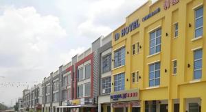 ein gelbes Gebäude mit vielen Fenstern an einer Straße in der Unterkunft ID Hotel Yayasan in Buluh Kasap