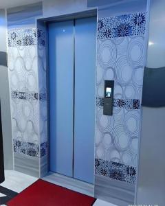 une salle de bains avec une porte bleue et une moquette rouge dans l'établissement ARK HOTEL BATU CAVES, à Batu Caves